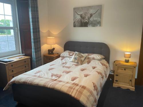 a bed in a bedroom with two nightstands and a bed with a cow at The Old Manse B&B in Thurso