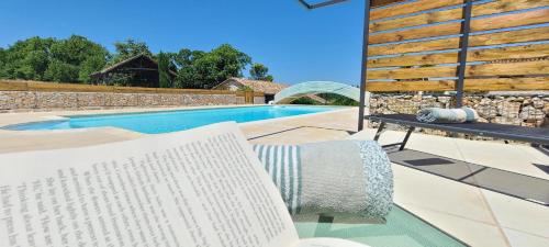 una piscina con un banco blanco junto a una piscina en Gite de Calvet, en Sainte-Croix