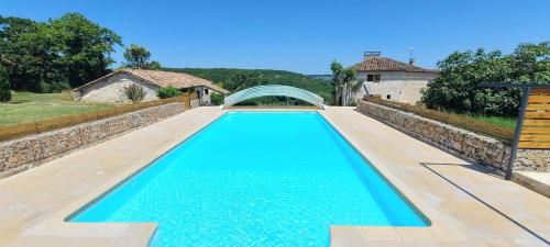 Una gran piscina azul frente a una casa en Gite de Calvet, en Sainte-Croix