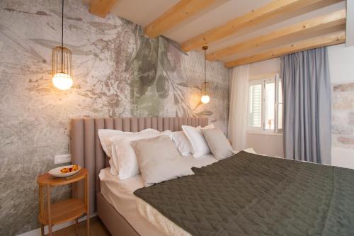 a bedroom with a large bed in a room at Heritage House Kaleta in Hvar