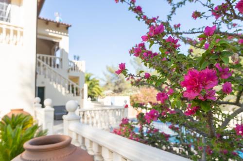 a white fence with pink flowers on it at Retiro Sol - Casa Joni in Orba