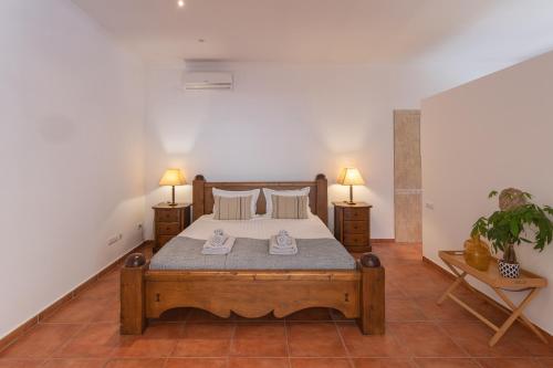 a bedroom with a bed and two lamps and a plant at Retiro Sol - Casa Joni in Orba