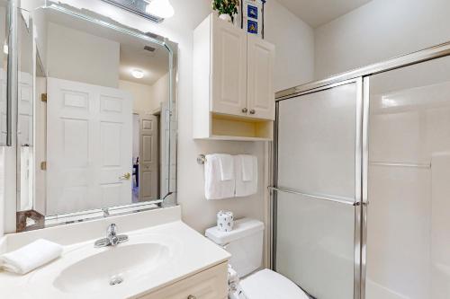 a white bathroom with a sink and a shower at Oasis on the Greens in Myrtle Beach