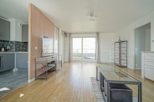 un grand salon avec une table et une grande fenêtre dans l'établissement Ideal & Central 3BR for Family & Friends, à Saint-Denis