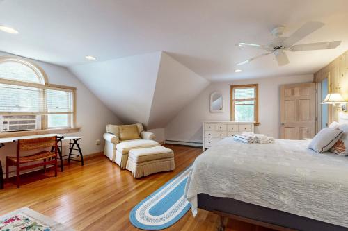 Un dormitorio con una cama, una silla y un escritorio. en Sea Pine Palace, en Wellfleet