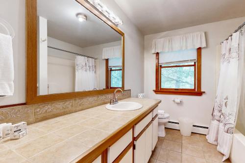 Un baño con lavabo, inodoro y espejo. en Sea Pine Palace, en Wellfleet