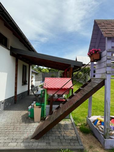 a house with a wooden deck and a table at Agroturystyka ‚U Misia’ in Krzywopłoty