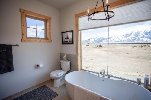 a bathroom with a tub and a toilet and a window at Sapphire Solace in Emigrant