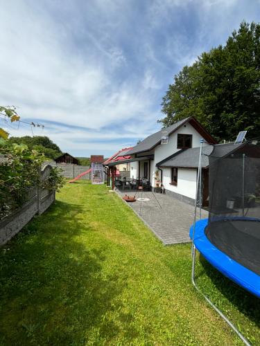 a yard with a house and a trampoline at Agroturystyka ‚U Misia’ in Krzywopłoty