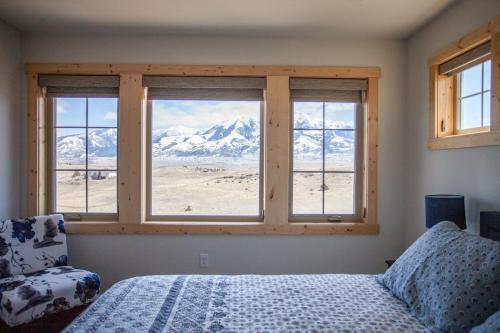 a bedroom with a bed and views of snow covered mountains at Sapphire Solace in Emigrant
