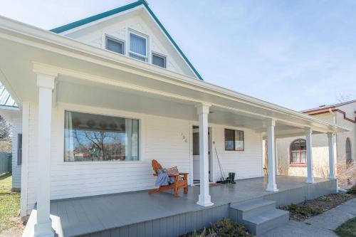 a porch of a white house with a bench on it at 7th Street Bungalow in Livingston