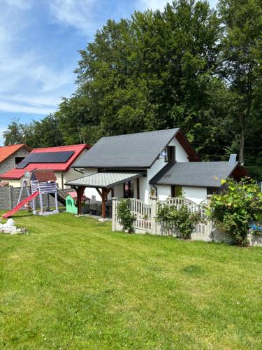 a house with a playground in a yard at Agroturystyka ‚U Misia’ in Krzywopłoty