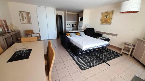 - un salon avec un lit et une table à manger dans l'établissement Résidence Les Rivages de Rochelongue - maeva Home - Appartement 3 pièces 6 personnes Confort - Vue mer MAE-1585, au Cap d'Agde