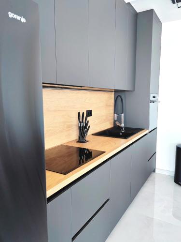 a kitchen with white cabinets and a wooden counter top at Villa Sea level with BEAUTIFUL VIEW, Medveja in Lovran