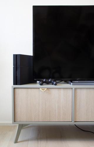 a flat screen tv sitting on top of a tv stand at Apartment im Luftkurort Kißlegg, frisch renoviert, Balkon, Boxspringbetten, SmartTV, Playstation, Kaffevollautomat, ruhig, familienfreundlich in Kißlegg