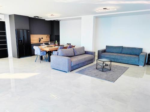 a living room with two blue couches and a table at Villa Sea level with BEAUTIFUL VIEW, Medveja in Lovran