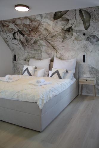 a bed in a bedroom with a stone wall at Apartment im Luftkurort Kißlegg, frisch renoviert, Balkon, Boxspringbetten, SmartTV, Playstation, Kaffevollautomat, ruhig, familienfreundlich in Kißlegg