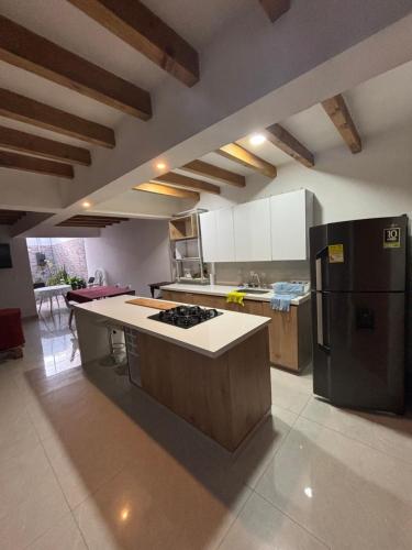 cocina con nevera negra y fogones en Casa familiar RS, en Villa de Leyva