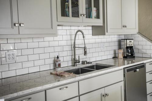 a kitchen with white cabinets and a sink at Fisherman's Bungalow in Livingston
