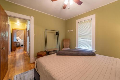 a bedroom with a bed with a ceiling fan and a window at Fisherman's Bungalow in Livingston