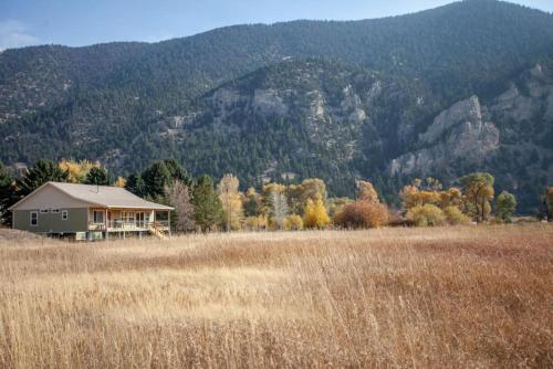 a house in a field with a mountain in the background at Evergreen in Livingston
