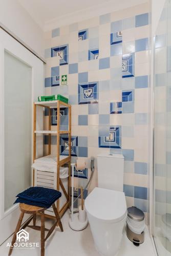 a bathroom with a toilet and a blue and white tiled wall at São Lourenço Apt - Amazing terrace with Sea View in Ericeira