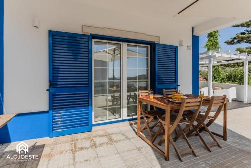 a dining room with blue shutters and a table and chairs at São Lourenço Apt - Amazing terrace with Sea View in Ericeira