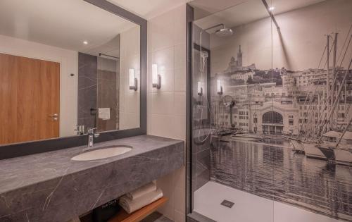 a bathroom with a sink and a mirror at Radisson Blu Hotel Marseille Vieux Port in Marseille