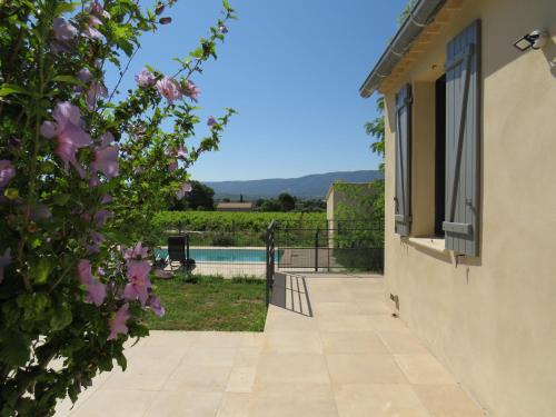 a view from the house of the pool and flowers at Maison face au Luberon avec piscine privée - 3 Chambres in Cabrières-dʼAvignon
