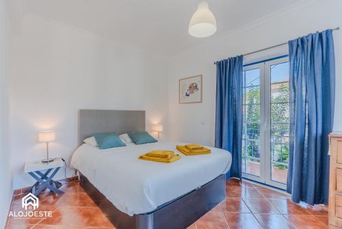 a bedroom with a large bed with blue curtains at São Lourenço Apt - Amazing terrace with Sea View in Ericeira