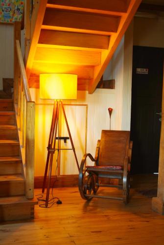 a lamp on a tripod next to a room with a chair at Casa Kalfu Hotel Boutique in Puerto Varas