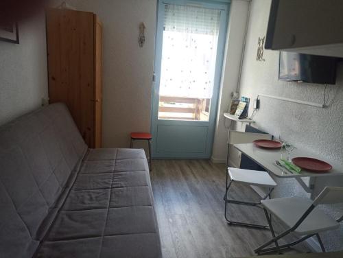 - un salon avec un canapé, une table et une porte dans l'établissement Appartement au calme, aux Rousses