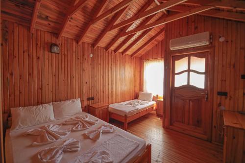 una camera con 2 letti in legno di YAVUZ MOTEL ADRASAN a Kumluca