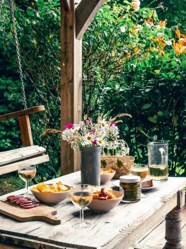 - une table avec des bols de nourriture et des verres de vin dans l'établissement Chalet chaleureux à Marigny-l'Église avec vue sur lac et montagne, à Marigny-lʼÉglise