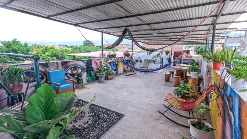 a patio with a hammock and potted plants at Shoffi's House Backpackers in Tarapoto