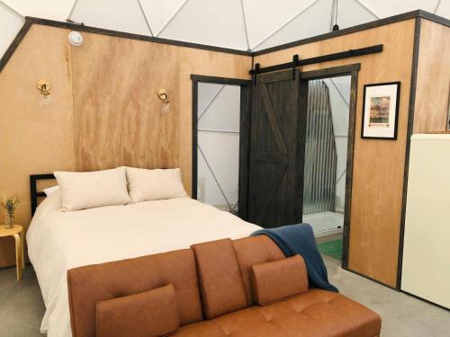 a bedroom with a large bed and a couch at Dome #3 in Livingston