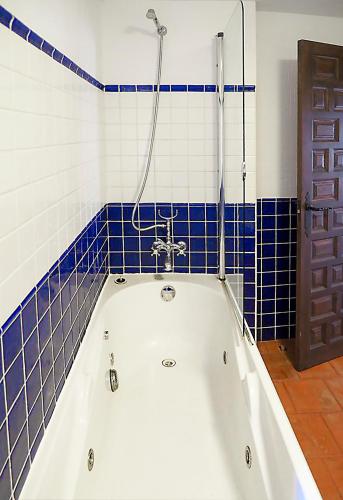 a bath tub in a bathroom with blue and white tiles at Apartamento Santo Domingo in Cuenca