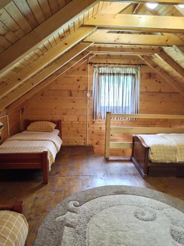 a attic room with two beds and a rug at Apartmani Kajkut in Banja Luka