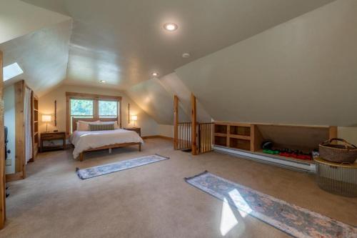 a attic bedroom with a bed and a large window at Garden House in Livingston