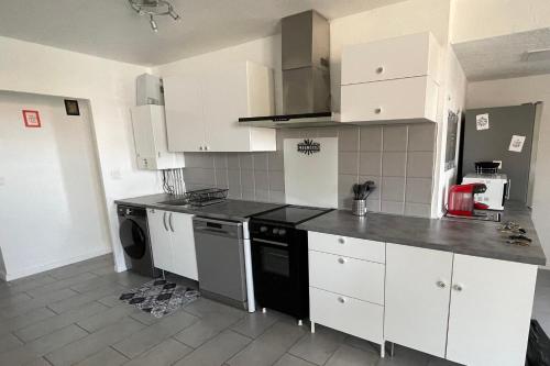 une cuisine avec des armoires blanches et un lave-vaisselle noir dans l'établissement Nice T4 with balcony near downtown Toulon, à Toulon