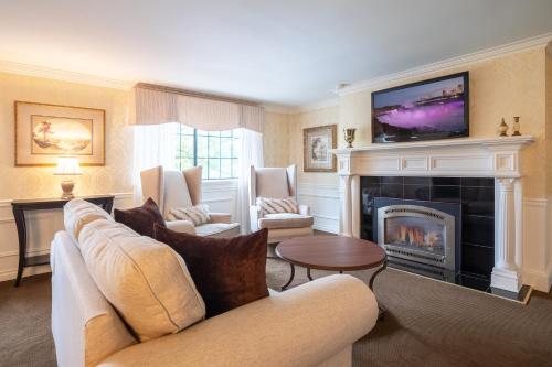 a living room with a fireplace and a tv at Red Coach Inn in Niagara Falls