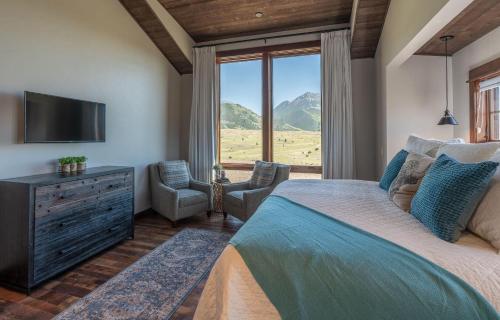a bedroom with a large bed and a television at Emigrant Peak Lodge in Pray