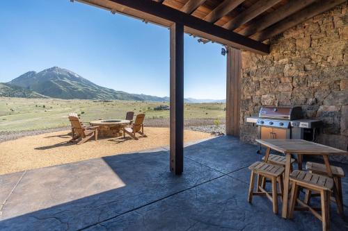 a patio with a table and a grill and a table and chairs at Emigrant Peak Lodge in Pray
