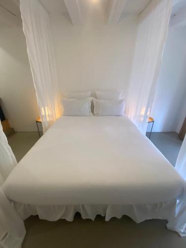 a large white bed with white sheets and pillows at Hebe la villa in Cogolin