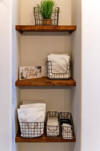 a bathroom with wooden shelves with baskets and towels at Double MM Ranch in Emigrant