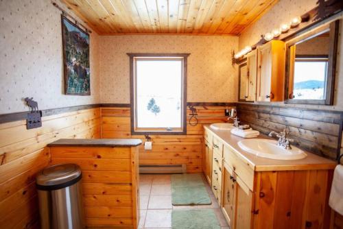 a wooden bathroom with a sink and a window at Rancho Deluxe Lodge in Livingston