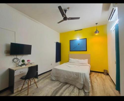a bedroom with a bed and a yellow wall at BACADI INN Tourist home in Ernakulam