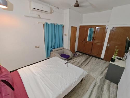 a room with a bed and a chair in it at BACADI INN Tourist home in Ernakulam