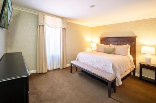 a hotel room with a bed and a window at Red Coach Inn in Niagara Falls