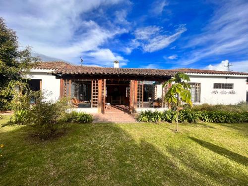 a large white house with a grass yard at Casa lila Hotel in Sesquilé